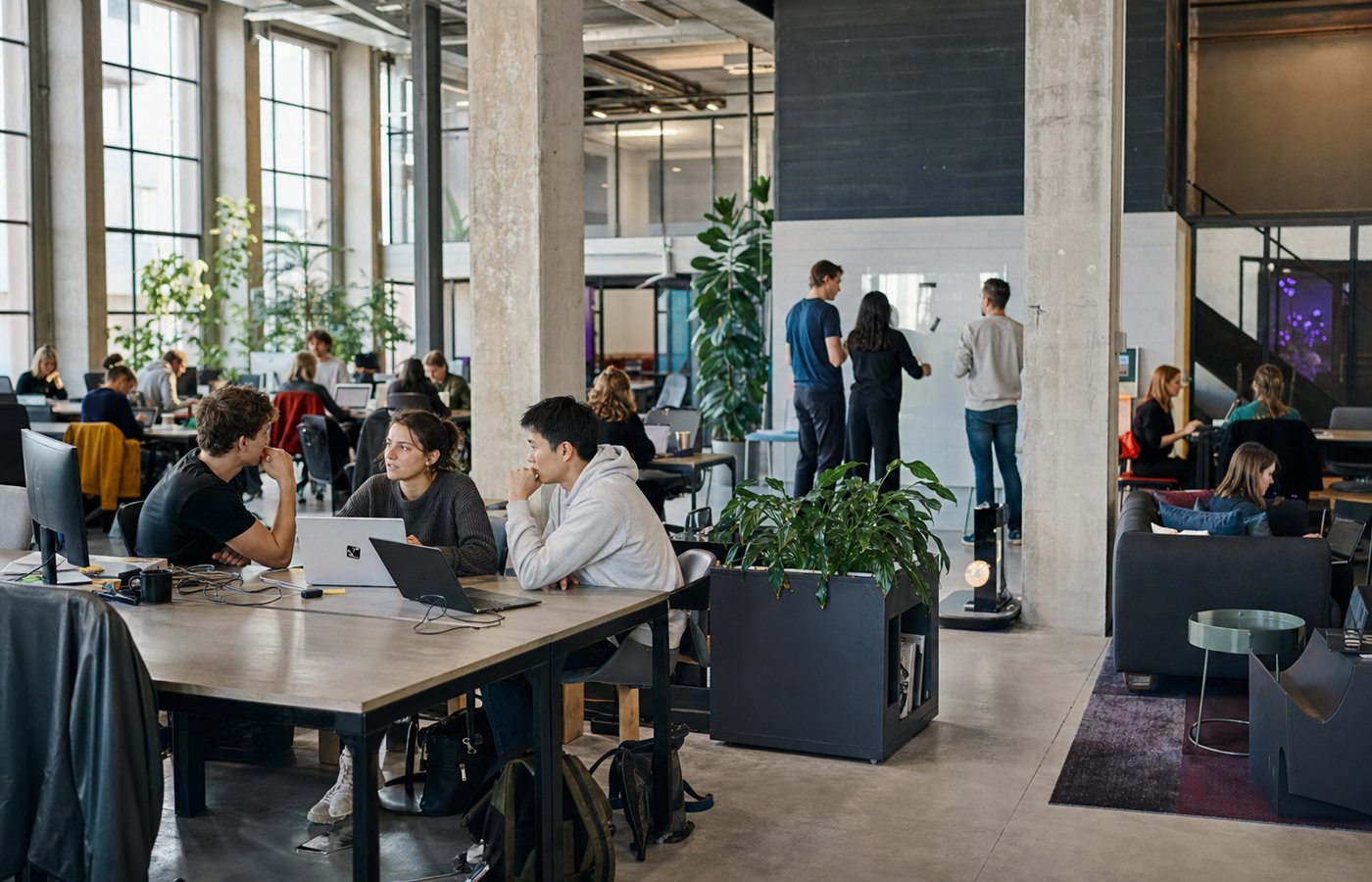 Students collaborating inside a bright industrial startup workspace